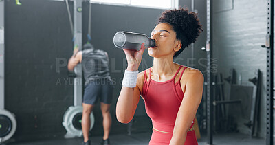 Black woman, rest and drinking water with bottle for fitness, wellness and health in gym. Young female, athlete or healthy lady relax, being thirsty after practice or training for exercise or workout