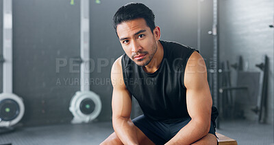 Gym, sports man and fitness training by man serious about health, wellness and competitive mindset. Face, portrait and asian instructor sitting before workout, exercise and cardio exercises in Japan