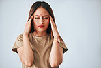 Headache, stress and woman in studio with anxiety, temple massage and pain against grey background. Burnout, brain fog and girl suffering migraine, vertigo or dizzy, fatigue or frustrated by problem 