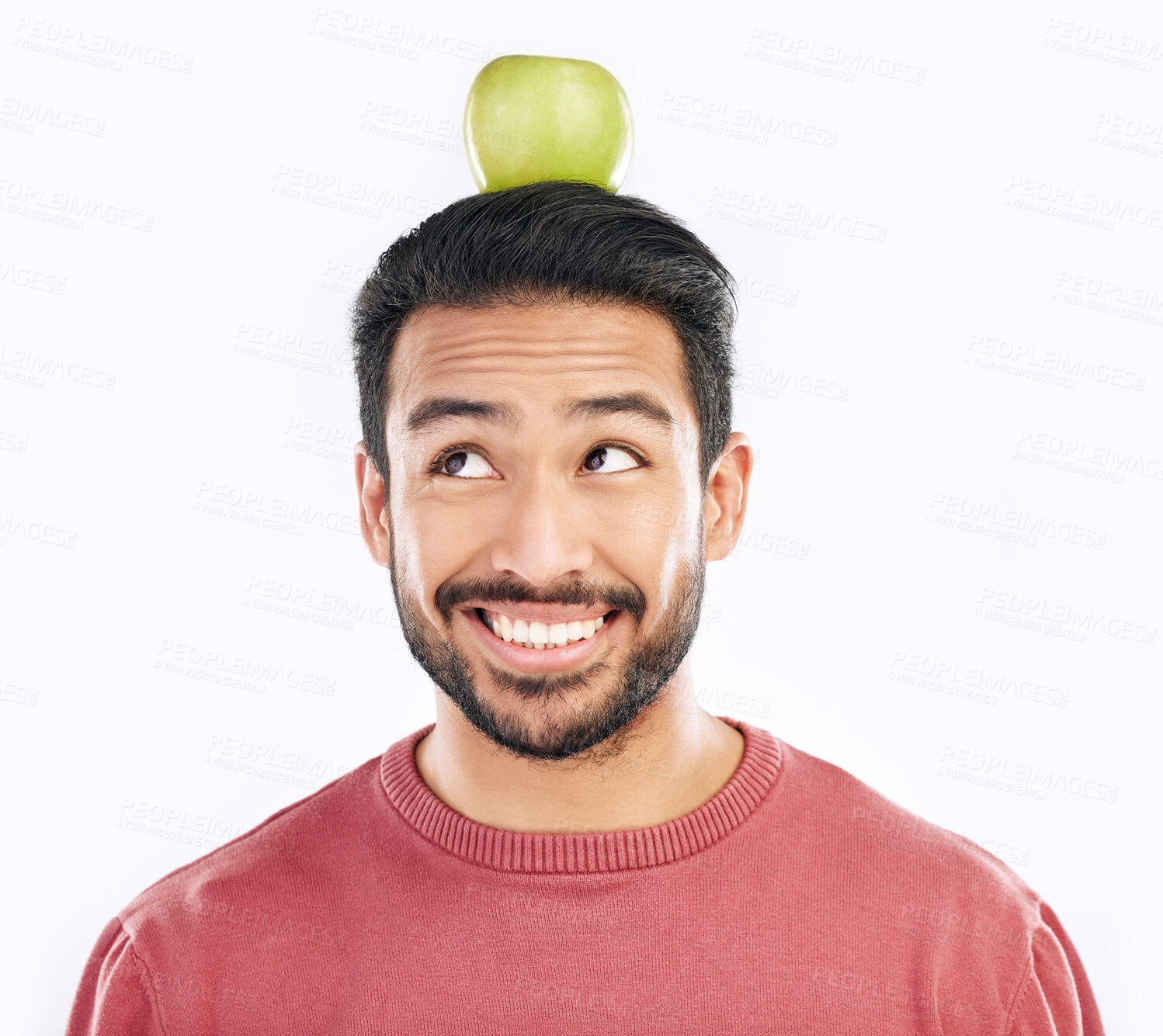 Buy stock photo Happy, apple and balance on a head with a man in studio isolated on a white background for diet or nutrition. Smile, nutritionist and food with a healthy young male balancing fruit for detox or fiber