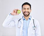 Doctor, man and apple in portrait with smile, health and nutritionist isolated on studio background. Medical professional, happy male physician and healthcare, promote healthy diet and nutrition