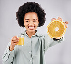 Portrait, orange and juice with a woman, happy in studio on a gray background for health or vitamin c. Face, drink and fruit with a young female drinking a fresh beverage in a glass for nutrition