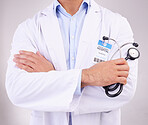 Arms crossed, stethoscope and man doctor in studio for healthcare, examination or check up on grey background. Hands, cardiovascular or health check by guy expert ready for consultation, exam or help