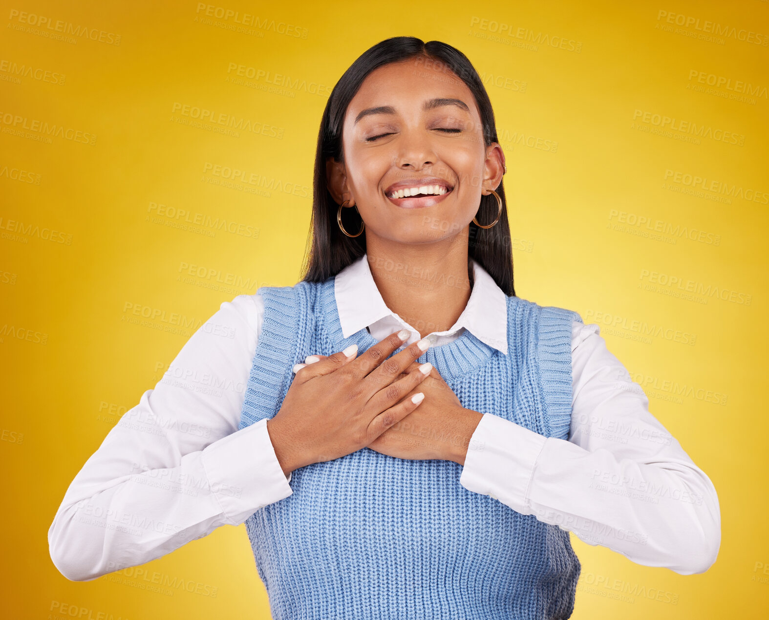 Buy stock photo Gratitude, happy and young woman in a studio with her hand on her chest for a grateful expression. Happiness, smile and Indian female model with a thankful hand gesture isolated by yellow background.