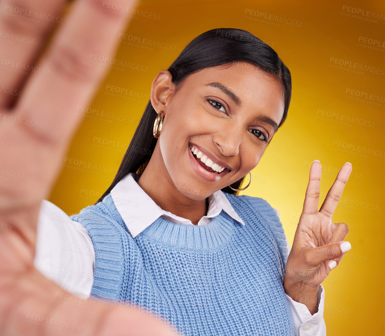 Buy stock photo Selfie, peace sign and portrait of Indian woman in studio for happiness, confident and smile on yellow background. Emoji mockup, fashion and girl with hand gesture with beauty, cosmetics and style