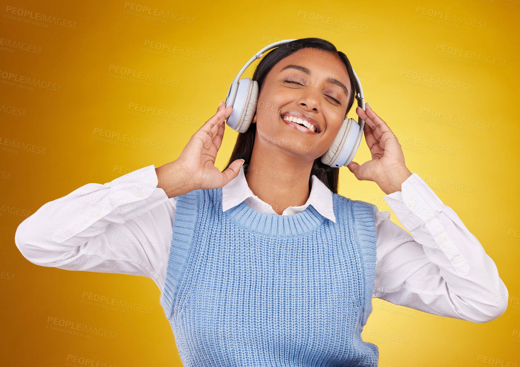 Buy stock photo Music headphones, studio and happy woman listening to media sound track for fun, freedom and wellness. Energy, audio podcast or Indian person streaming radio, playlist or song on yellow background
