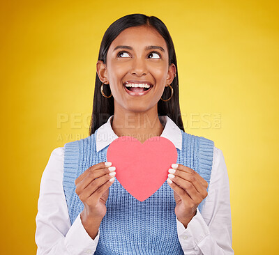 Buy stock photo Smile, paper and heart with woman in studio for love, support and romance. Valentines day, kindness and date with female and holding symbol on yellow background for health, happiness and hope mockup