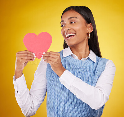 Buy stock photo Happy, paper and heart with woman in studio for love, support and romance. Valentines day, kindness and date with female and holding symbol on yellow background for health, happiness and hope