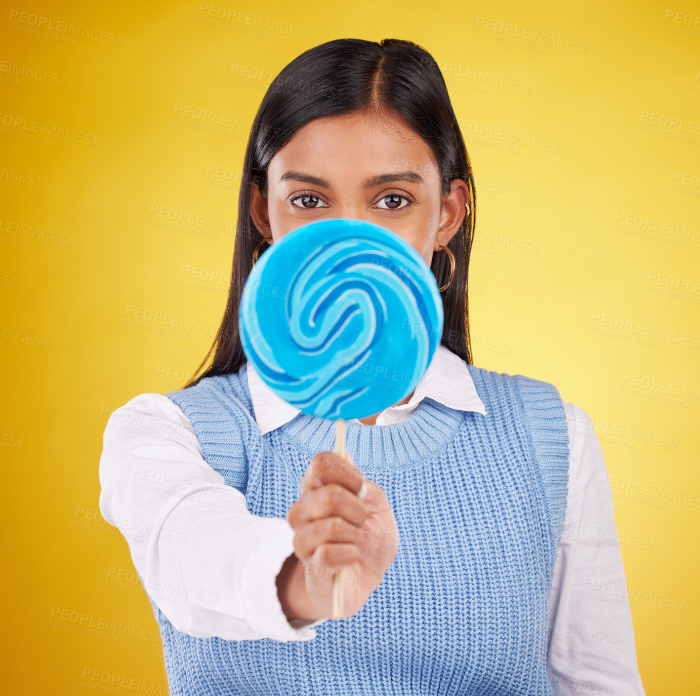 Buy stock photo Hide, lollipop and candy with portrait of woman in studio for sweets, snack and food. Treats, dessert and sugar confectionery with female isolated on yellow background for diet, eating and cover