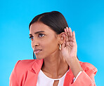 Listening, secret and gossip with a woman on a blue background in studio cupping her ear for hearing. Privacy, whisper and hand gesture with an attractive young female trying to hear news or a rumor