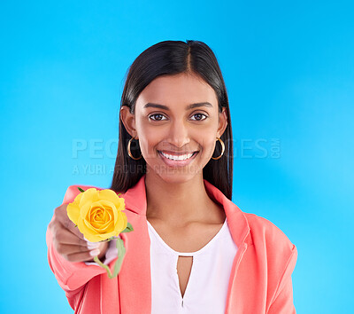 Buy stock photo Portrait, rose and valentines day with a woman on a blue background in studio for love or romance. Face, happy and smile with an attractive young female holding a yellow flower as a romantic gift