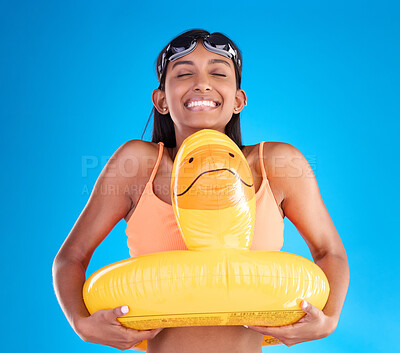 Buy stock photo Smile, goggles and rubber duck with a woman on a blue background in studio ready for summer swimming. Happy, travel and vacation with an attractive young female feeling excited to relax or swim