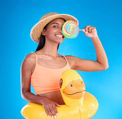 Buy stock photo Pool float, happy woman and portrait in a studio with lollipop sweet and swimsuit with a smile. Isolated, blue background and holiday outfit of a young female with happiness and candy feeling fun