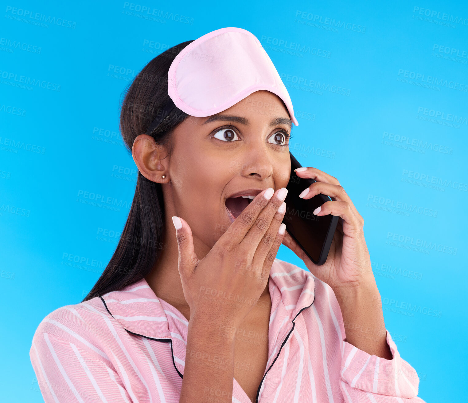 Buy stock photo Phone call, surprise and female in pyjamas in studio with shocking, winning or good news. Communication, shock and woman model having gossip conversation with wtf, omg or wow face by blue background.