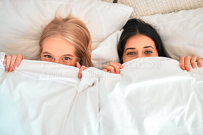 Buy stock photo Above, portrait and women covering with blanket for hiding, shy and cold in a bed. Sleep, relax and friends with a duvet to cover face for happiness, funny and warmth in the bedroom together