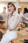 Portrait, meeting and boardroom with a business woman in the office for planning, strategy or management. Training, seminar and smile with a happy female employee sitting on a table during a workshop