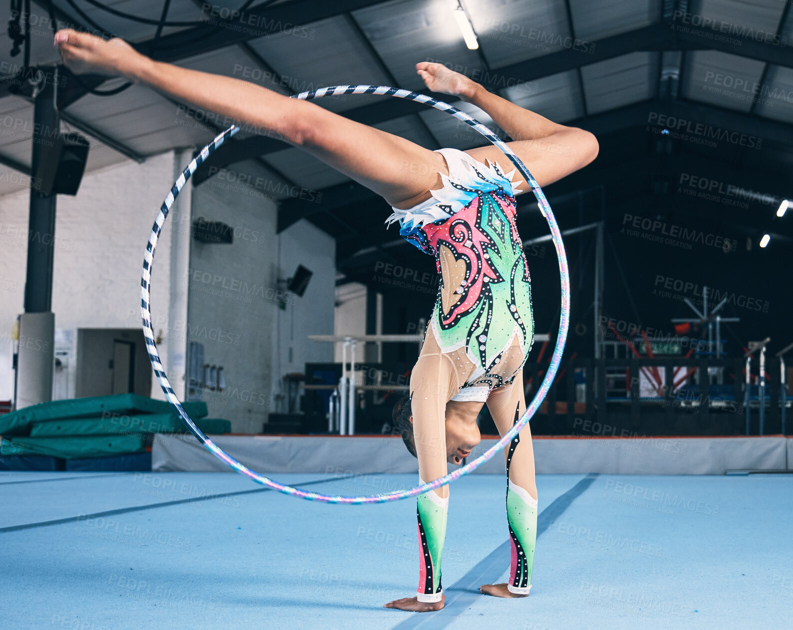 Buy stock photo Sports, gymnastics and woman with a hula hoop for a performance in a professional arena. Fitness, rhythm and female athlete or gymnast doing a flexibility and strength trick training for competition.