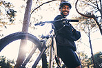 Forest, fitness and portrait of cyclist with bicycle in nature with smile, adventure trail and health from below. Cycling, woods and man with mountain bike in trees for workout, motivation or energy.
