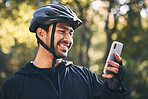 Man, cycling and outdoor with a phone for communication in nature for sports, exercise or training app. Athlete male person with helmet and smile for fitness workout with smartphone for travel or gps