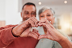 Couple, senior and heart hands in home, love and bonding in retirement together. Romance, hand gesture and elderly man and woman with emoji for care, affection and empathy, commitment and trust.