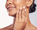 Hand, mouth and facial with a mature woman in studio for skincare, anti aging treatment or cosmetics. Beauty, skin and wellness with a senior female moisturizing her face for hydration closeup