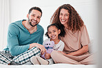 Portrait, love and family in bed, smile and cheerful with quality time, comfortable and joyful. Face, parents and mother with father, female child and daughter in bedroom, interracial and happiness