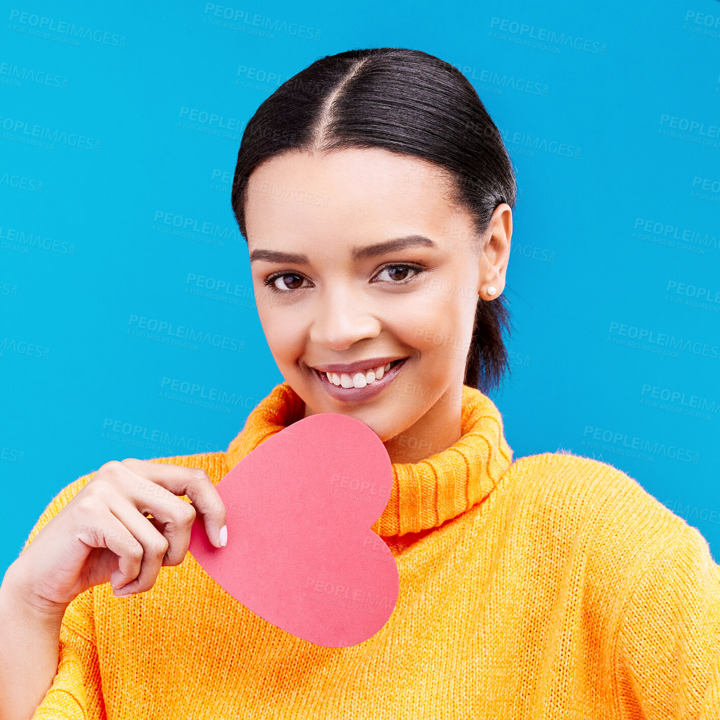 Buy stock photo Paper heart, portrait and happy woman on blue background, love icon and romantic flirting sign. Female model, emoji shape and smile of care, support and thank you for kindness, valentines day or date