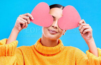 Buy stock photo Heart eyes, cover and woman smile with happiness and excited for love, valentines day or studio emoji. Happy, loving or person on isolated blue background, creative romance paper and show care symbol