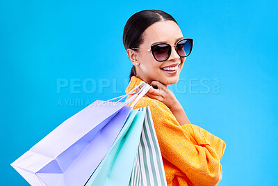 Buy stock photo Shopping bags, studio and woman portrait with deal and happiness from boutique sale. Happy, customer and wealthy female model with store bag and sales choice in isolated blue background with person
