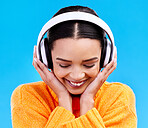 Music headphones, woman and smile on blue background, studio and color backdrop. Happy female model listening to sound, streaming album and audio connection on media, gen z and hearing radio podcast