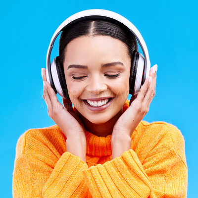 Buy stock photo Headphones, happy woman and listening to music on blue background, studio and color backdrop. Gen z female model streaming audio, album and media connection to radio, sound and subscription podcast