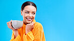 Coffee, woman and smile in studio with mockup and happiness and mug. Isolated, blue background and happy female model and young person with casual winter fashion and joy from tea drink smiling