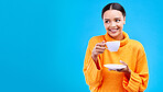 Tea, woman and smile in studio with mockup and happiness and mug. Isolated, blue background and happy female model and young person relax with casual winter fashion and joy from hot drink smiling