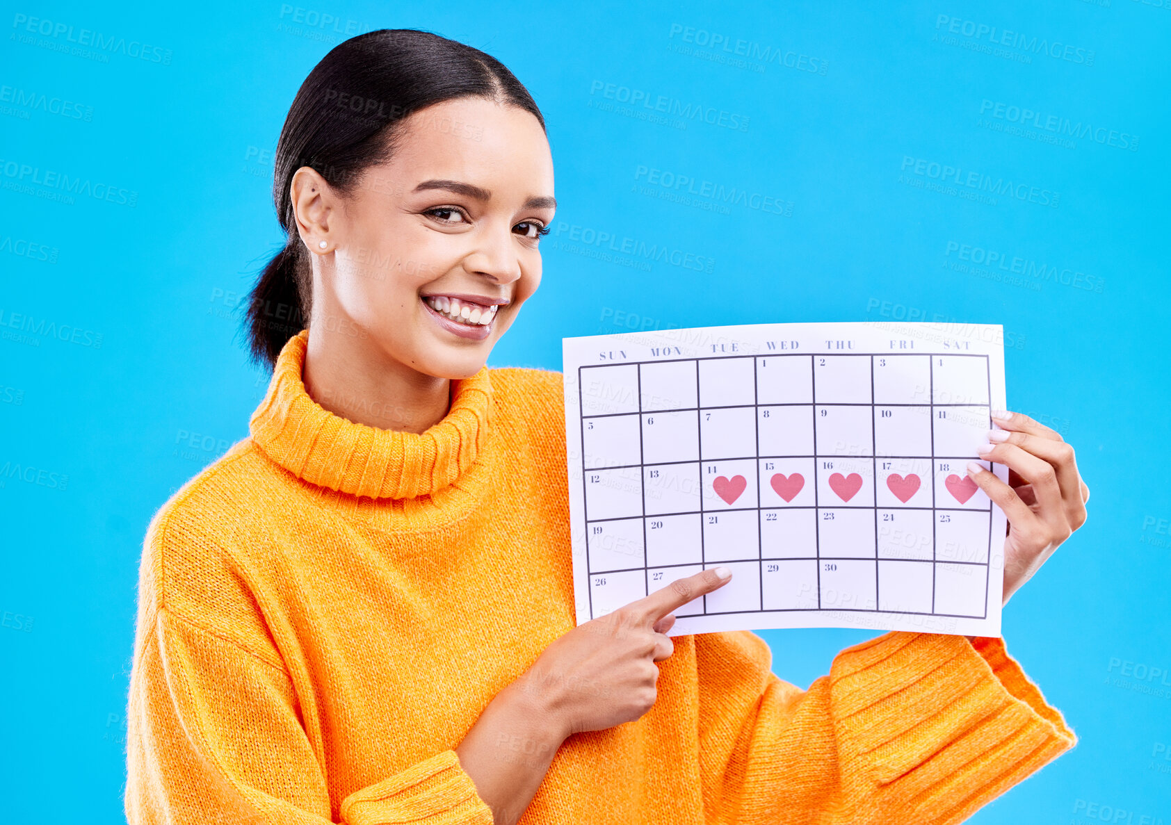 Buy stock photo Happy, portrait and woman with a calendar in a studio to track her menstrual or ovulation cycle. Happy, smile and face of a female model pointing to a paper period chart isolated by a blue background