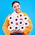 Toilet paper, young woman and portrait with happiness and smile in a studio. Isolated, blue background and happy female person and youth model with tissue rolls stock and gen z fashion smiling