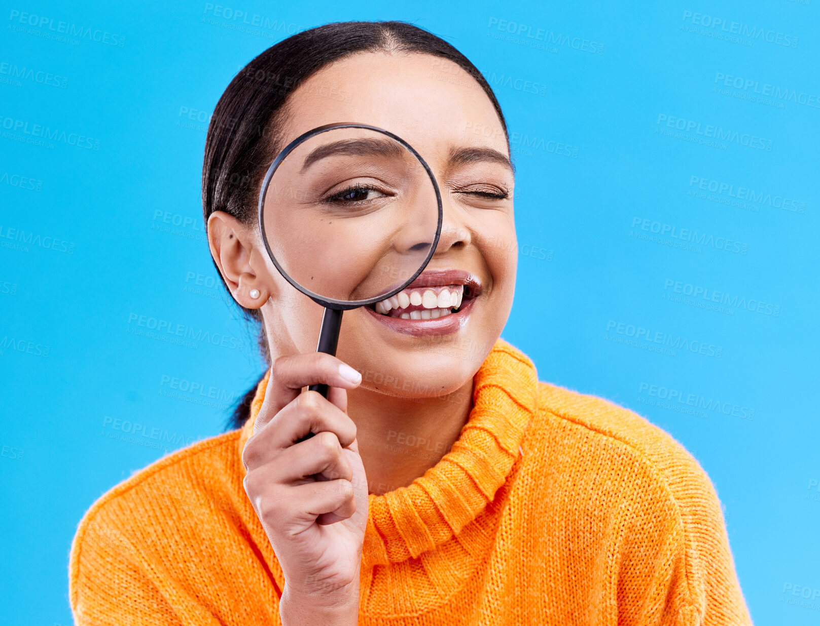 Buy stock photo Happy, portrait and female with a magnifying glass in a studio for an investigation or detective cosplay. Happiness, smile and headshot of a female model with a magnifier isolated by blue background.