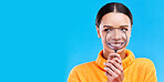 Happy, smile and woman with magnifying glass in studio for zoom on her mouth for dental health. Happiness, excited and female model from Brazil with magnifier isolated by blue background with mockup.