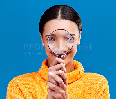 Buy stock photo Woman, magnifying glass and smile in studio portrait with funny face, search and zoom by blue background. Gen z girl, investigation and research with lens for study, inspection and check by backdrop