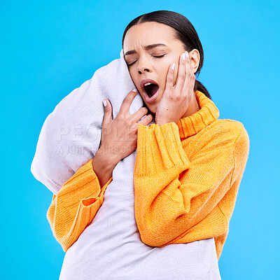 Buy stock photo Tired woman, pillow and yawn in studio with exhausted face, and ready to sleep by blue background. Girl, model and open mouth for sleeping, rest or nap for self care, mental health and peace of mind