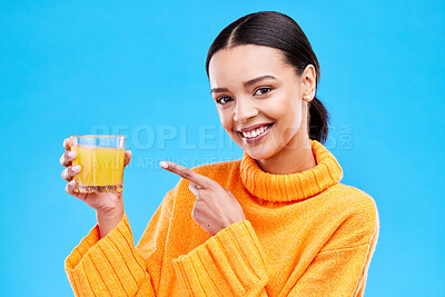 Buy stock photo Happy woman, portrait and pointing to orange juice in studio, blue background and backdrop. Female model, drinking glass and fruit cocktail beverage for nutrition, diet and detox health of vitamin c