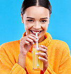 Happy woman, portrait and straw for drinking orange juice in studio, blue background and smile. Female model, glass and sip of fruit cocktail for nutrition, vitamin c diet and detox vegan smoothie
