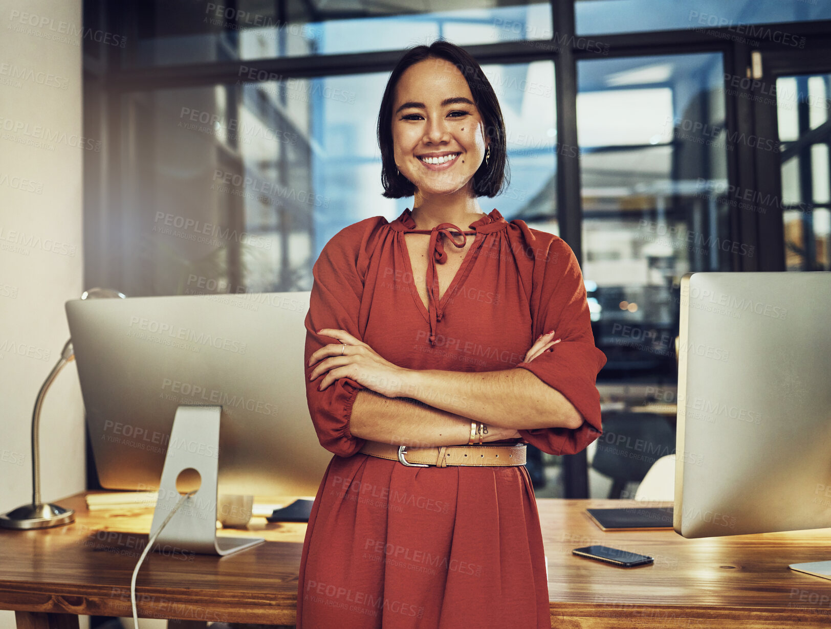 Buy stock photo Portrait, smile and late with a business woman in her office, arms crossed while working in the evening at night. Vision, happy and dark with an asian female employee standing at work for dedication