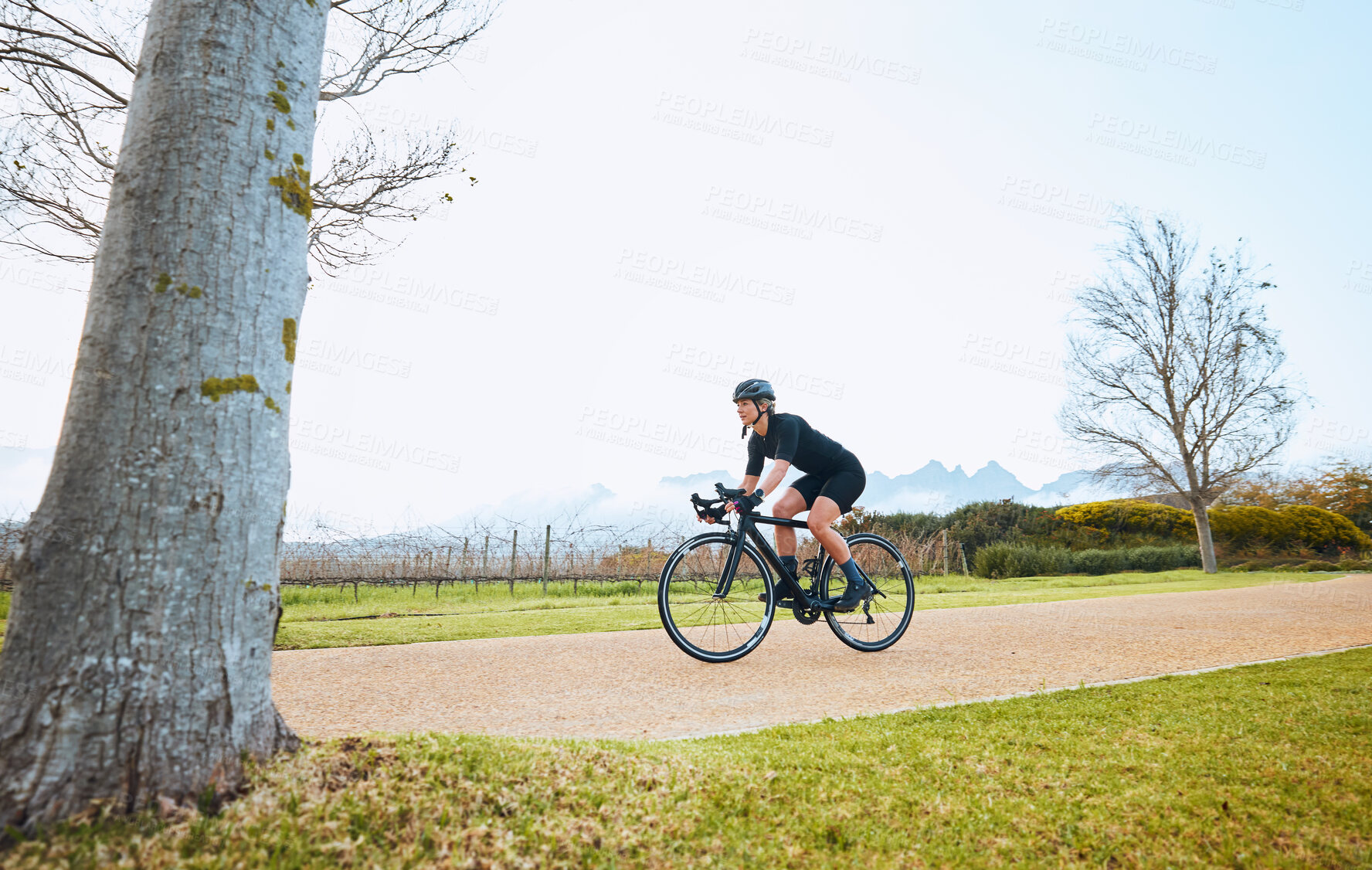 Buy stock photo Cycling, fitness and sports with woman in park for training, workout and health mockup. Exercise, travel and freedom with female cyclist riding on bike in nature for adventure, journey and transport