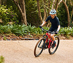 Fitness, nature and woman riding a bicycle while training for a race, marathon or competition. Sports, workout and female athlete cyclist doing a cardio exercise on a bike on an outdoor trail in park