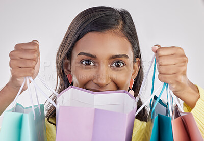 Buy stock photo Portrait, shopping and eyes with a woman customer in studio on a gray background for retail or consumerism.  Fashion, luxury and excitement with a female consumer or shopper showing bags of bargains