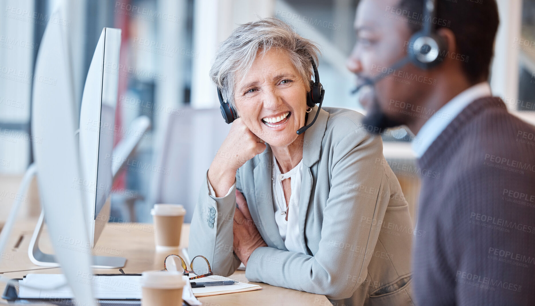 Buy stock photo Call center, team talking and laughing woman in office with coworker, funny joke or comedy. Telemarketing, contact us and happy elderly person, friends and black man laugh at customer service humour