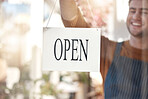 Happy businessman, open sign and small business ready for service, customer help or advertising at store. Man waiter smiling at entrance setting up shop or opening label, poster or billboard at cafe