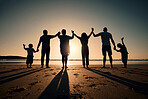 Silhouette, beach and family holding hands in sunset on a holiday or vacation at sea or ocean together. Travel, love and shadow of people celebrate in support, freedom and bonding at night or evening