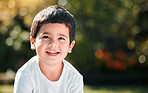 Children, thinking and mockup with a boy in a park or garden, alone outdoor during a summer day. Kids, idea and smile with a happy male child outside in nature for freedom on a blurred background