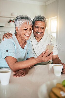 Buy stock photo Phone, video call and elderly couple in a kitchen happy, smile and embrace in their home. Smartphone, love and old people pose for selfie, photo or profile picture while enjoying retirement together